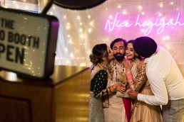 happy couple get surprised by kisses as they pose for the photo booth