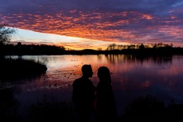 bride and groom silhouetted in front of a fantastic sunset at Hardwick Hall