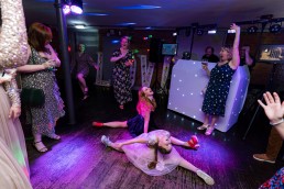 two people do the splits on the dance floor of West Mill in Derby whilst onlookers cheer