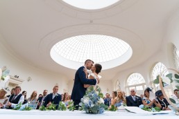 couple kiss under the domes of the orangery at Barton Hall