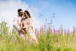 bride and groom pose amongst the wild flowers at Last Drop Village