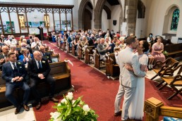 couple share a kiss in front of their guests in a church in Sheffield