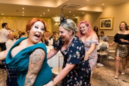 wedding guests form a conga train as singing waiters perform