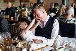 father and daughter tickling and wrestling at a wedding