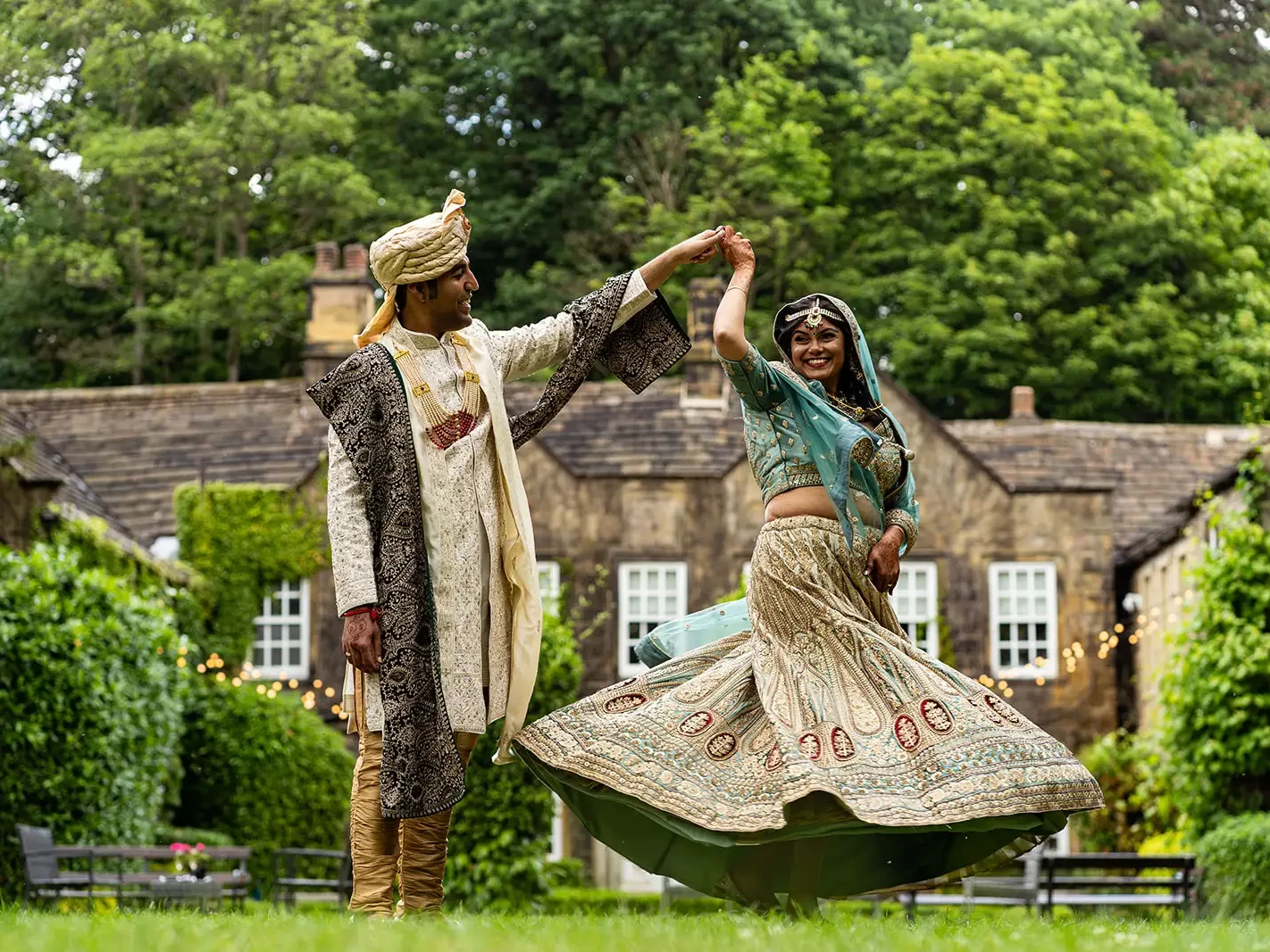 indian bride and greoom dance on the lawn of whitley hall, a top sheffield wedding venue