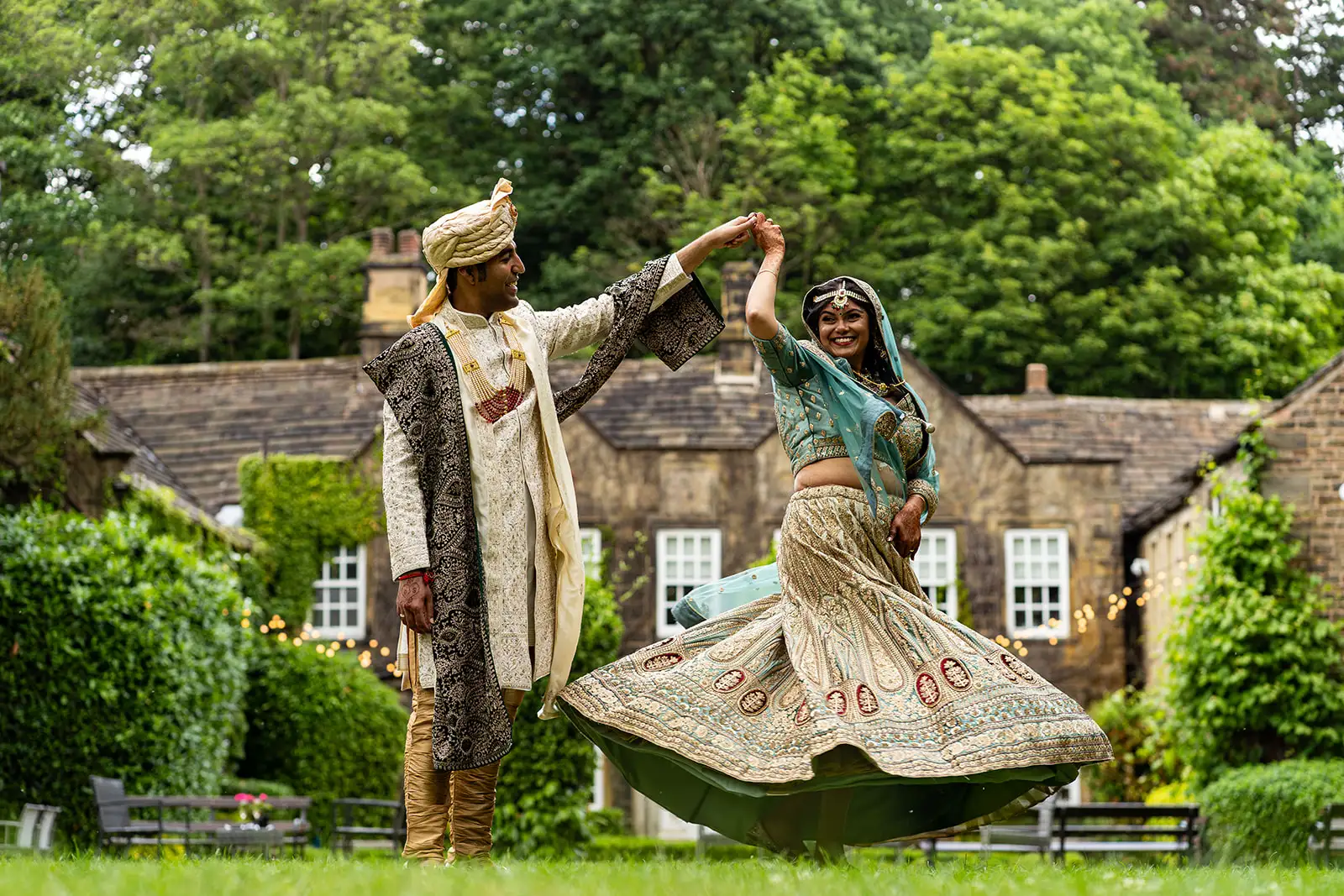 indian bride and greoom dance on the lawn of whitley hall, a top sheffield wedding venue