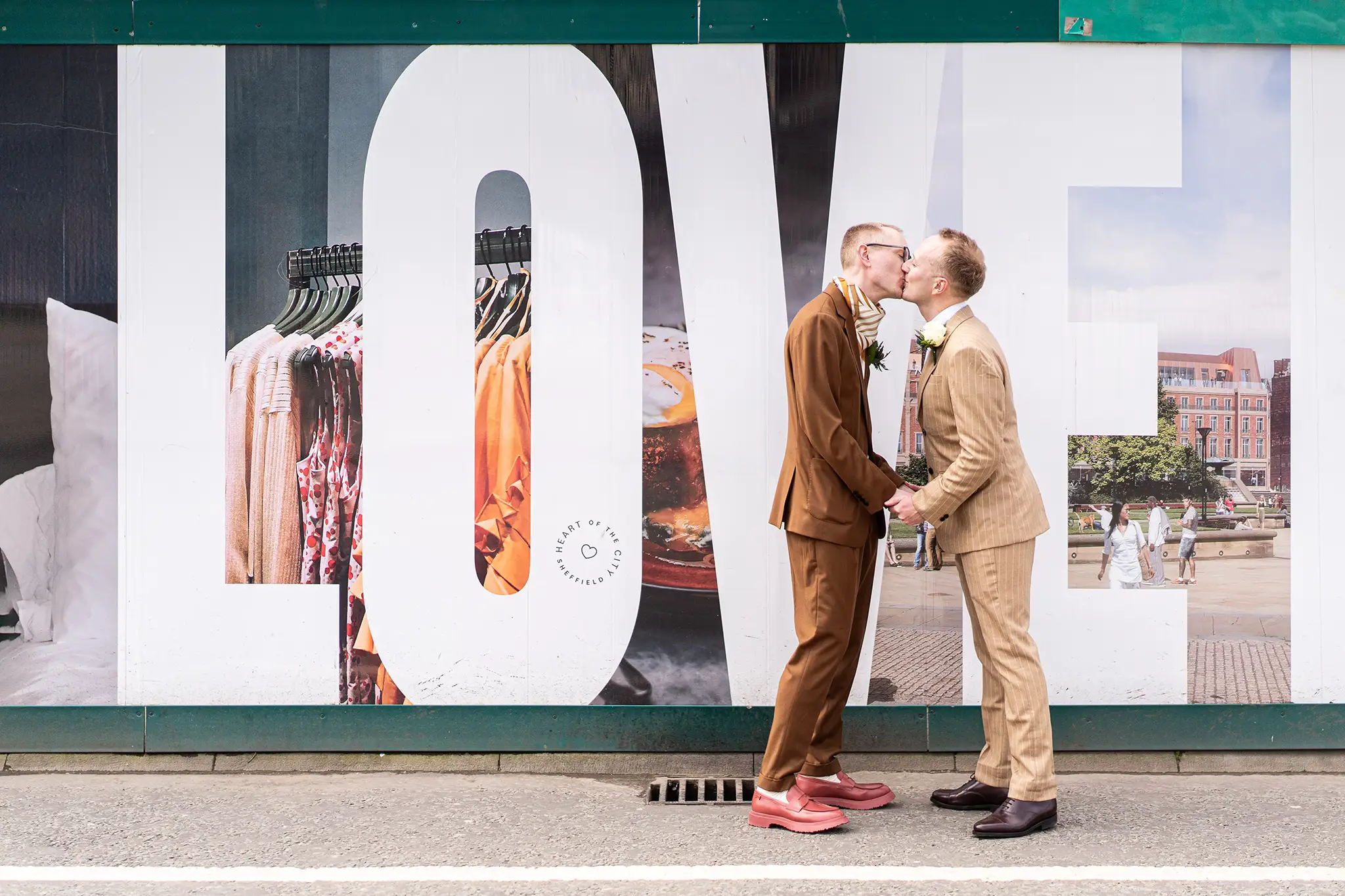 Sheffield wedding photographer Nate Dainty capturing a first look in front of a hoarding with LOVE written on it