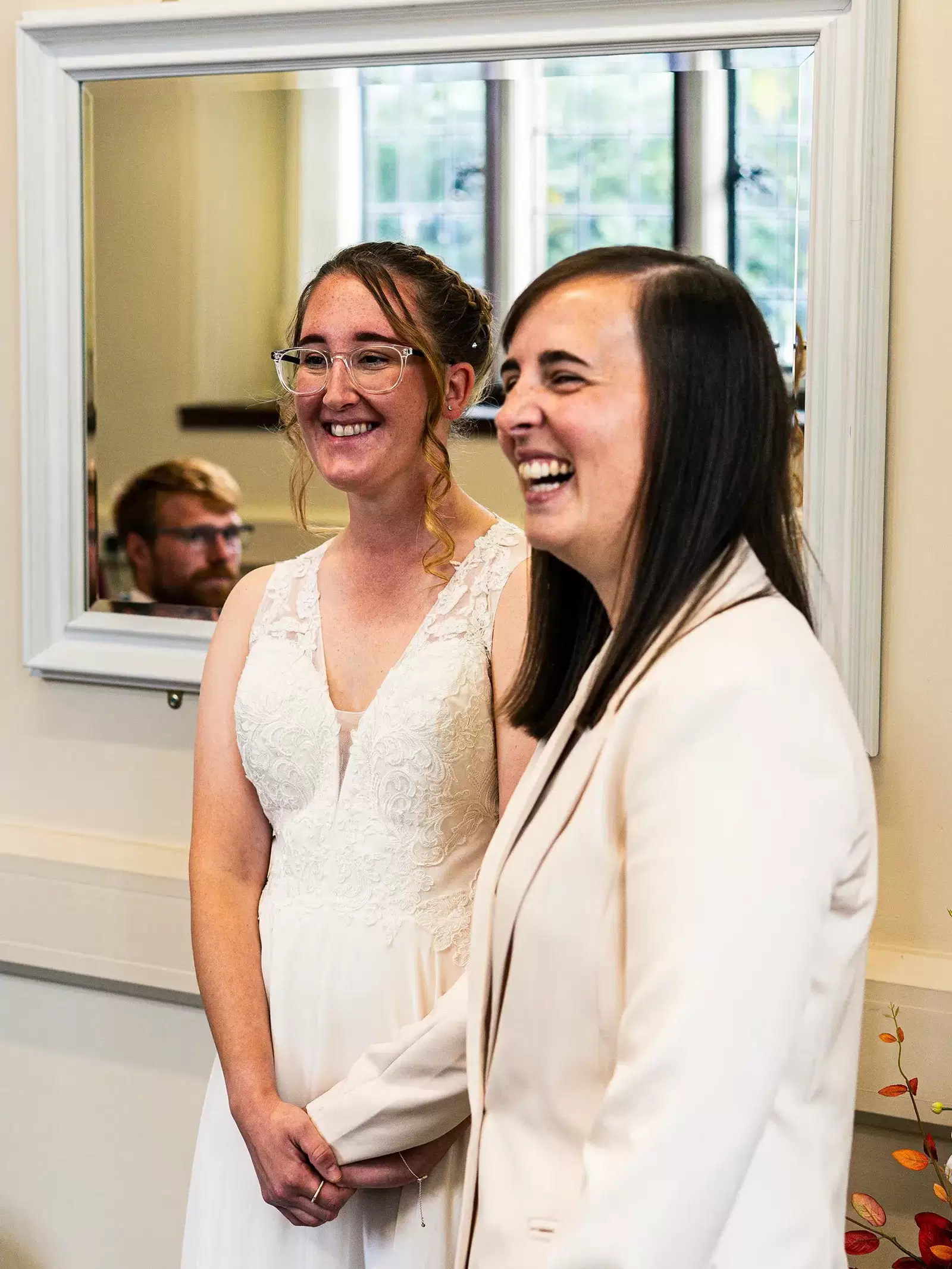 Two brides smiling during their wedding ceremony in the Loxley Room at Sheffield Town Hall